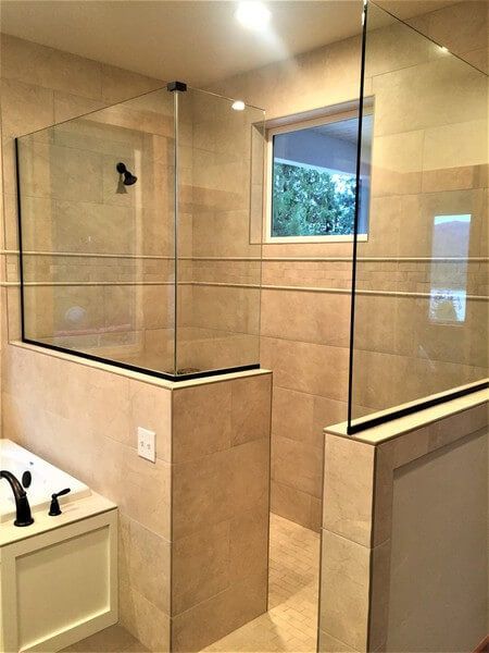 A bathroom with a walk in shower and a bathtub.