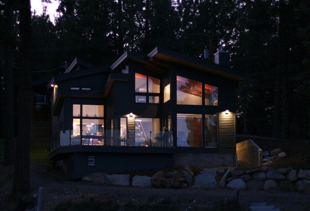 A house with a lot of windows is lit up at night