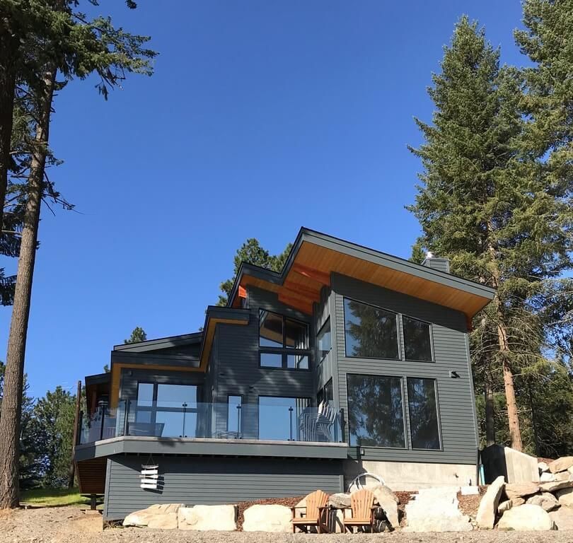 A large house with a lot of windows is surrounded by trees