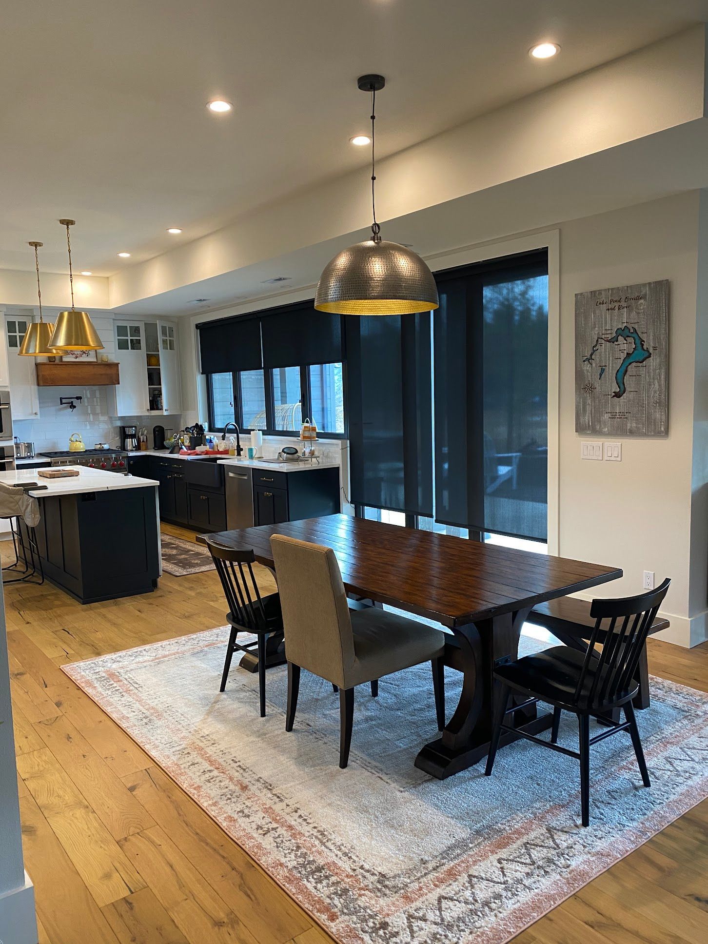 A dining room with a table and chairs and a rug on the floor.