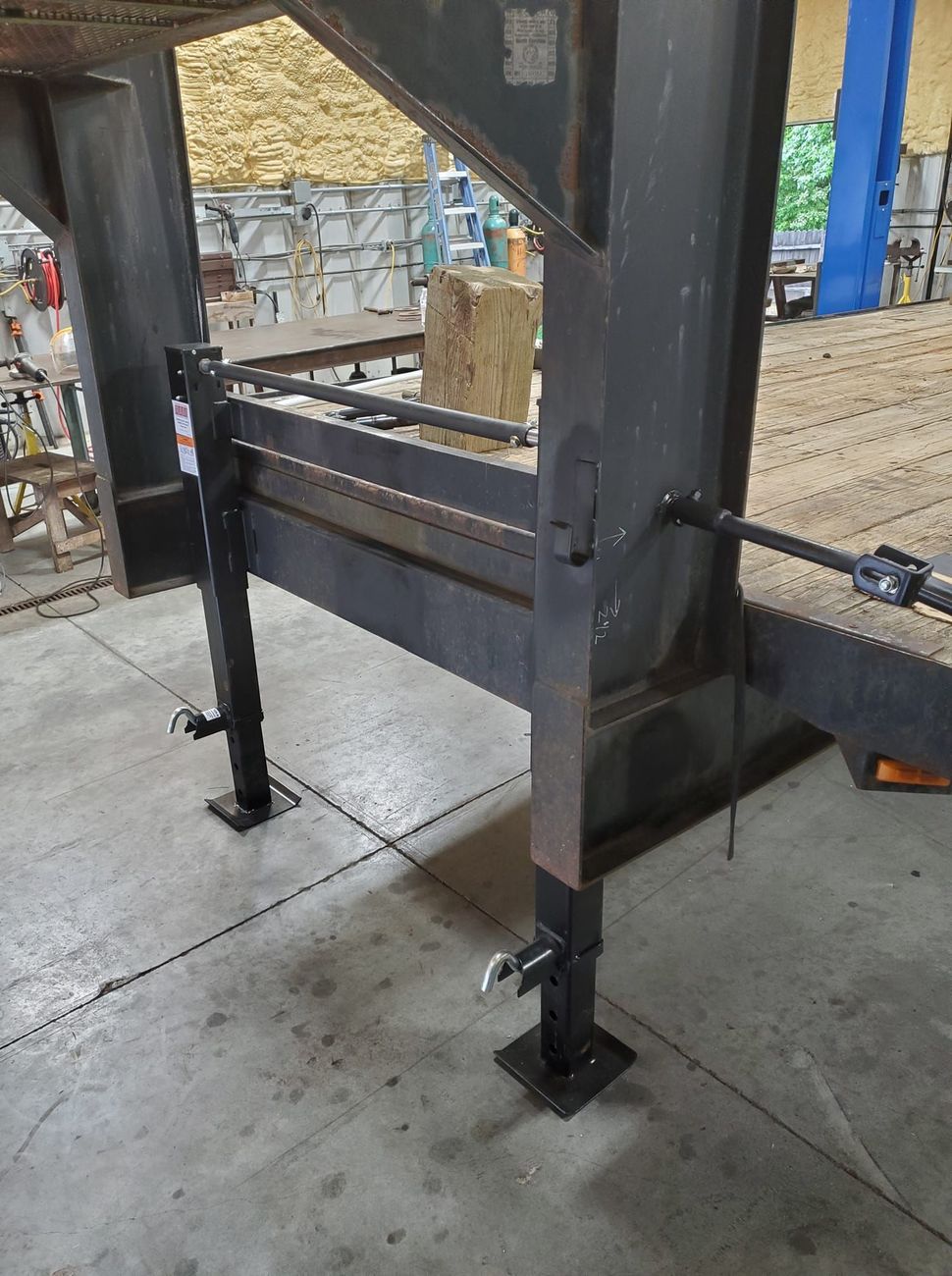 A large metal structure is sitting on the ground in a warehouse.