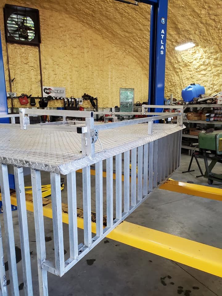 A metal fence is in a garage next to a lift.