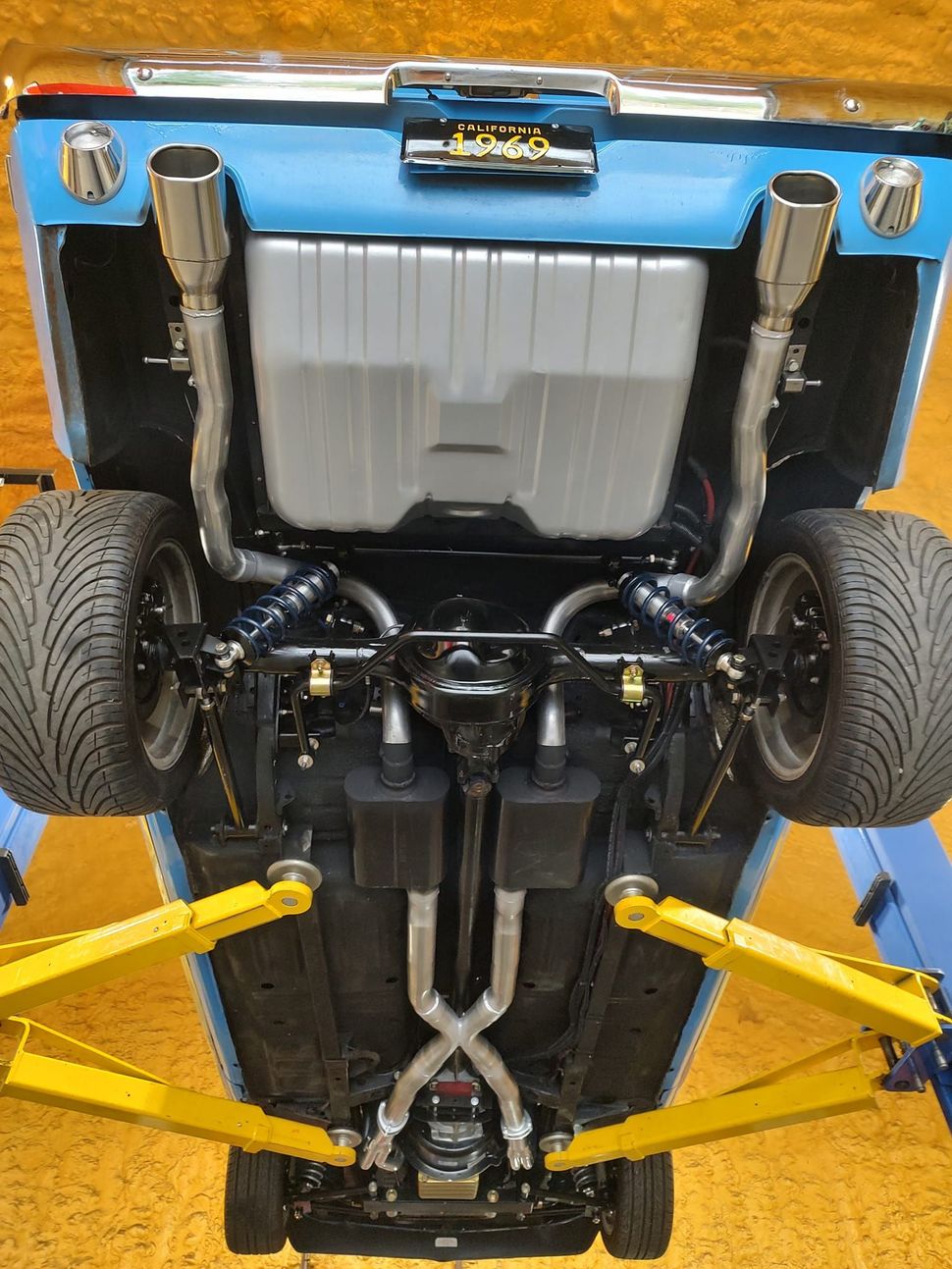A close up of the underside of a car with exhaust pipes.