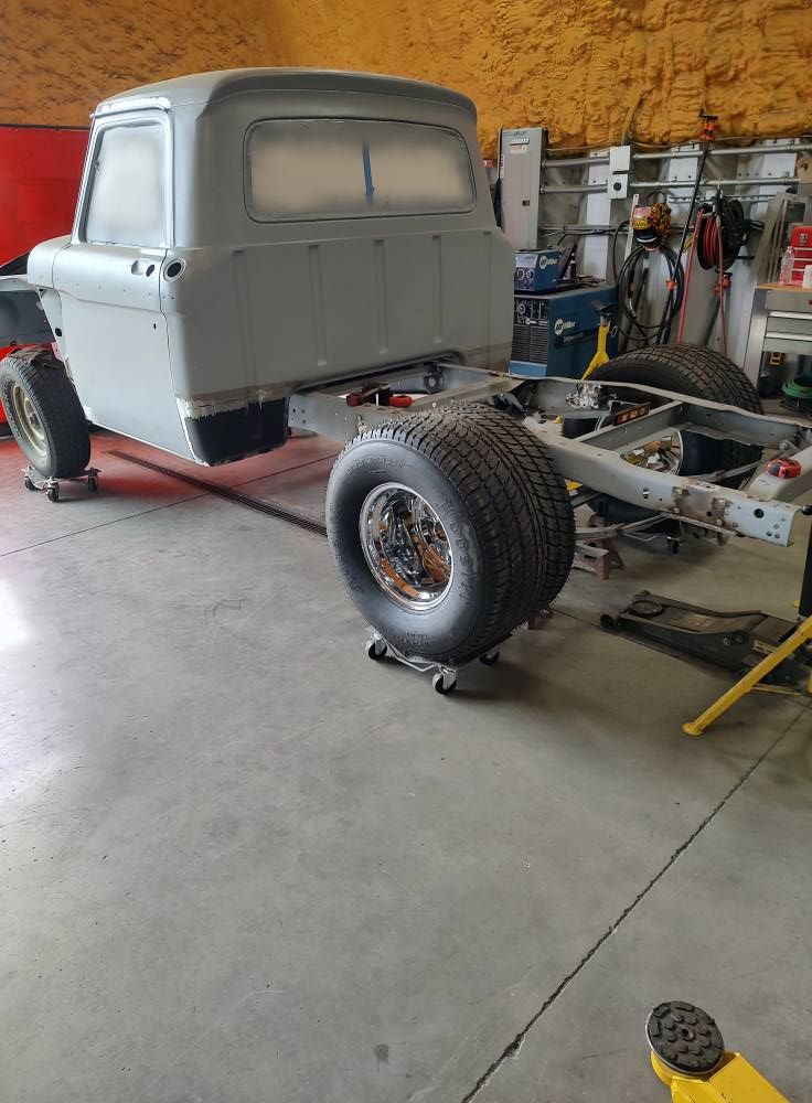 A truck is sitting on a lift in a garage.