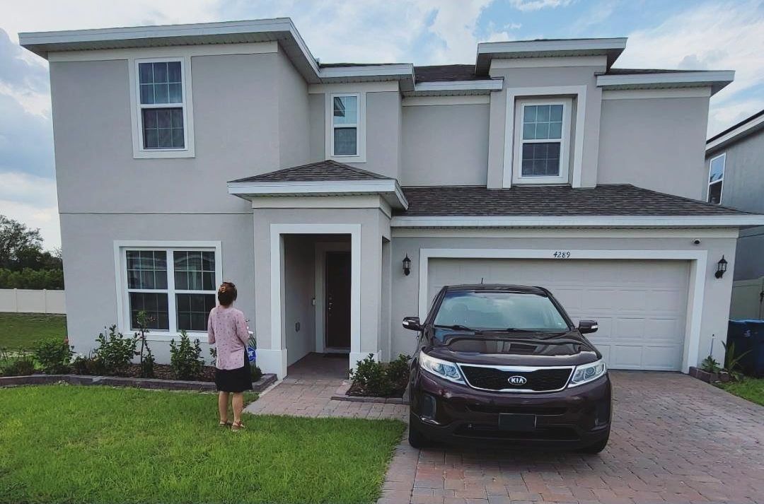 A before picture of a house with a car parked in front of it