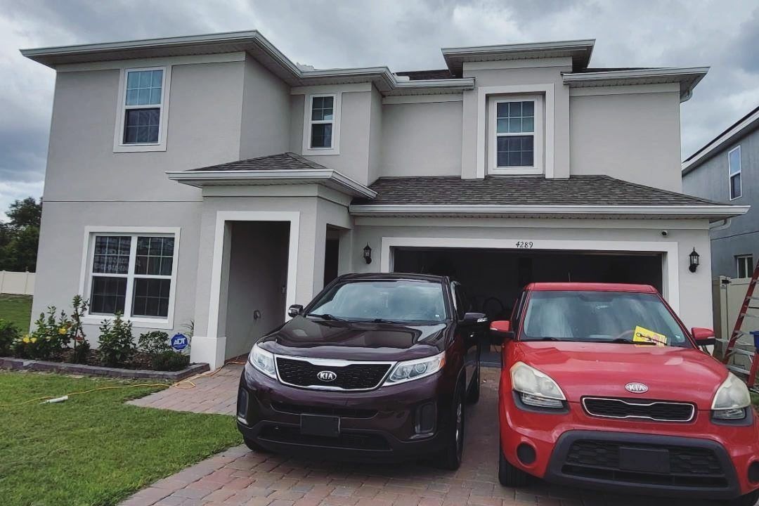 Two cars are parked in front of a house with a sign that says after
