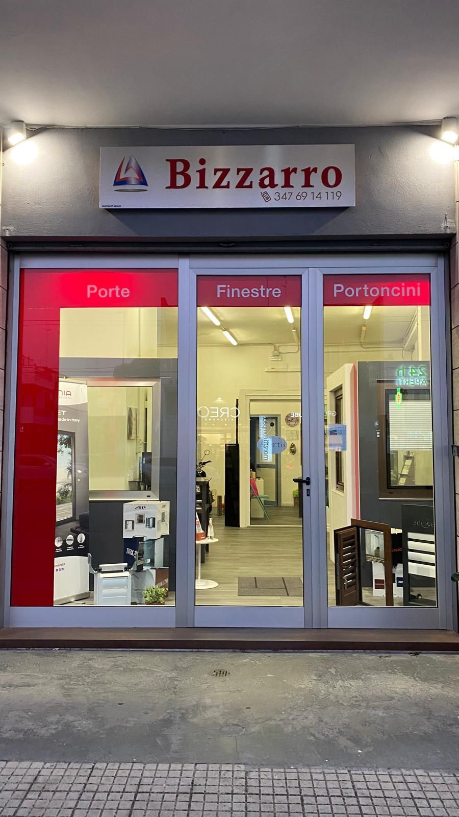 Una mano che mescola un cappuccino schiumoso in una tazza nera Mado, un croissant e dei bicchieri d'acqua su un tavolo.