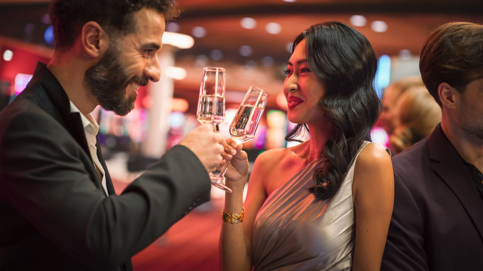 A Man And A Woman Are Toasting With Champagne Glasses At A Casino — Pittsfield, MA — Black Luxe Luxury Car