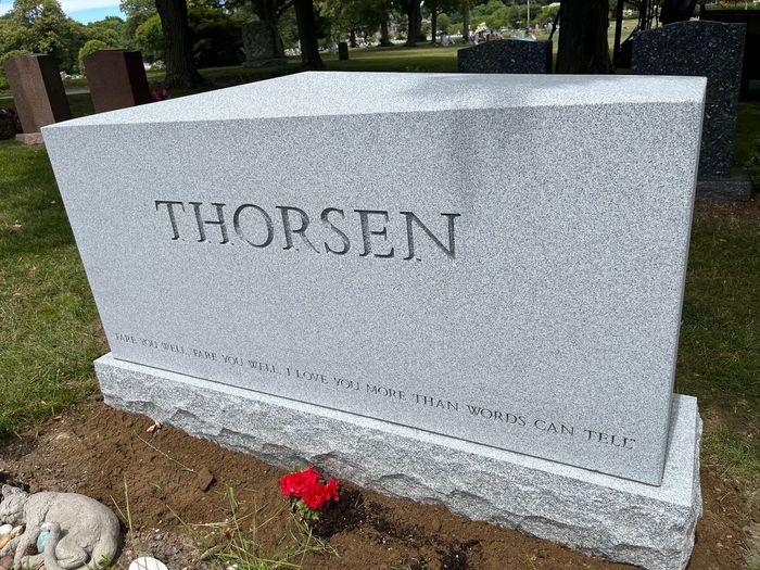 A gray granite stone with an apex top with the name Thorsen inscribed in larger lettering