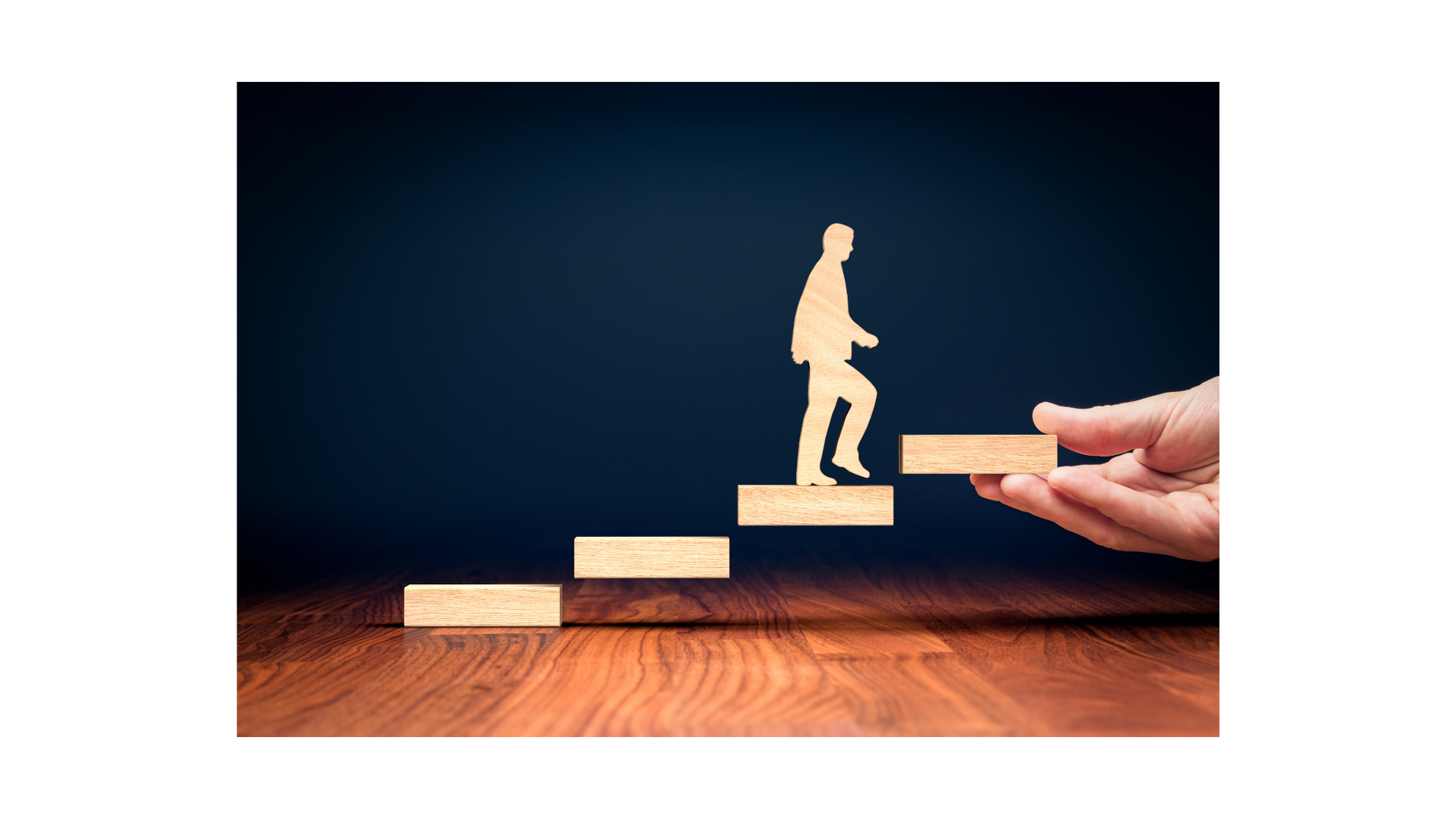 A person is holding a wooden block with a silhouette of a man walking up the stairs.