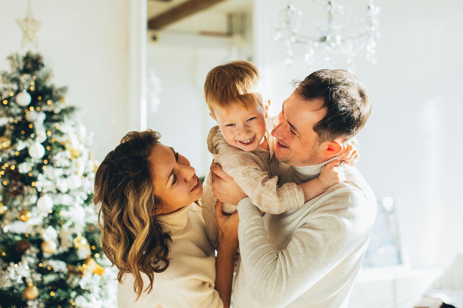 A family is posing for a picture in front of a christmas tree.