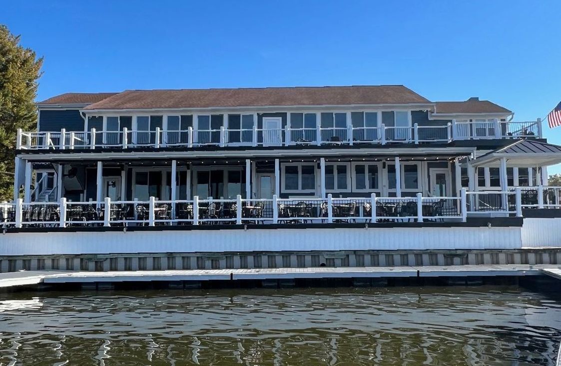 A large house is sitting on top of a body of water.