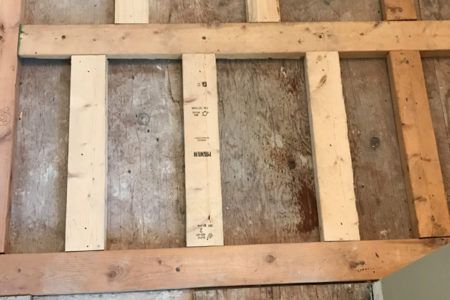 A wooden frame is sitting on top of a wooden floor.