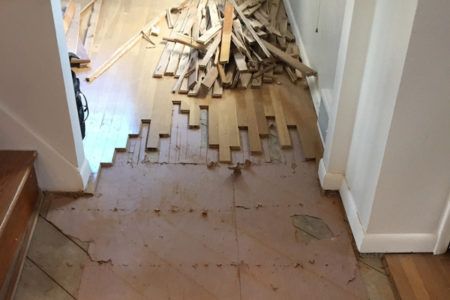 A hallway with a pile of wood on the floor.