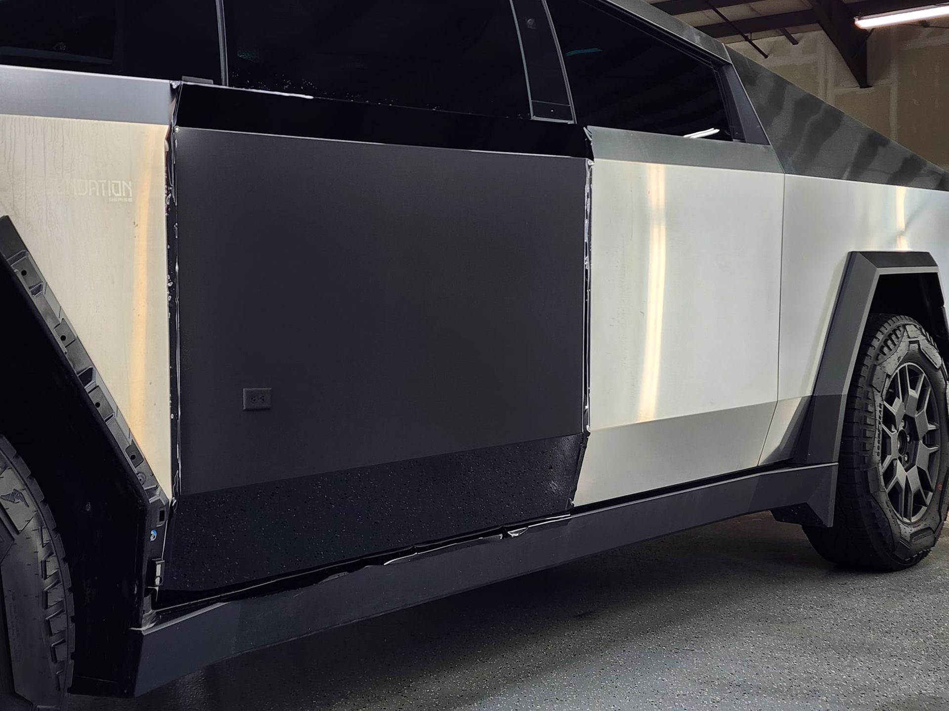 A black and white car is parked in a garage