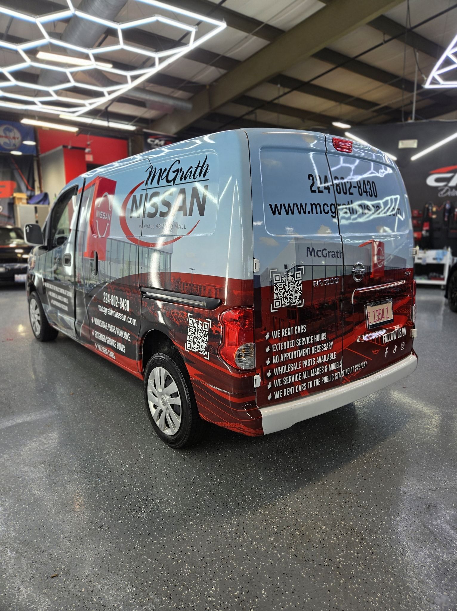 Hand wiping a shiny black car with a bright green microfiber cloth.