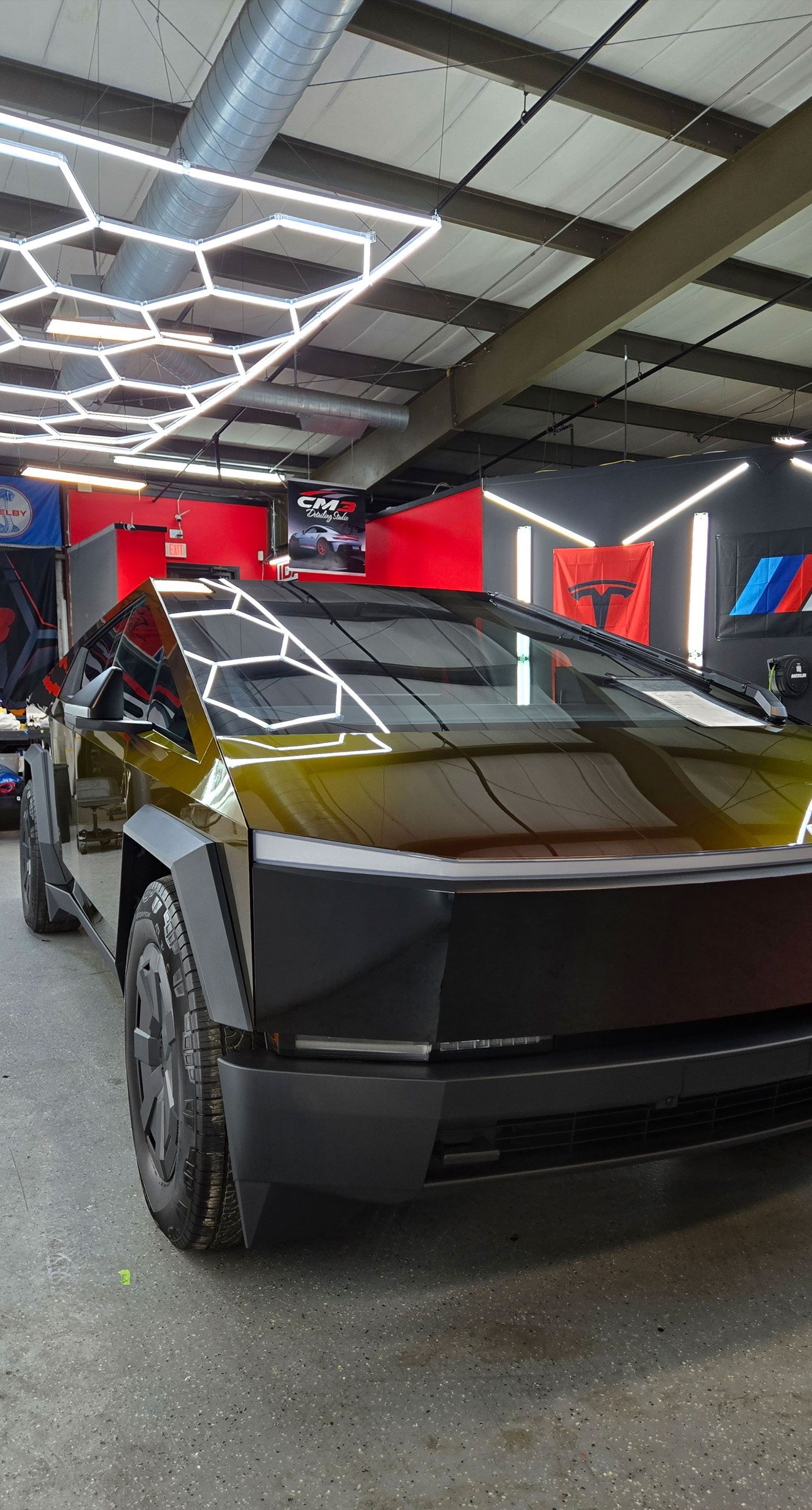 Person's hand smoothing blue film on a car's rear, near a red taillight.