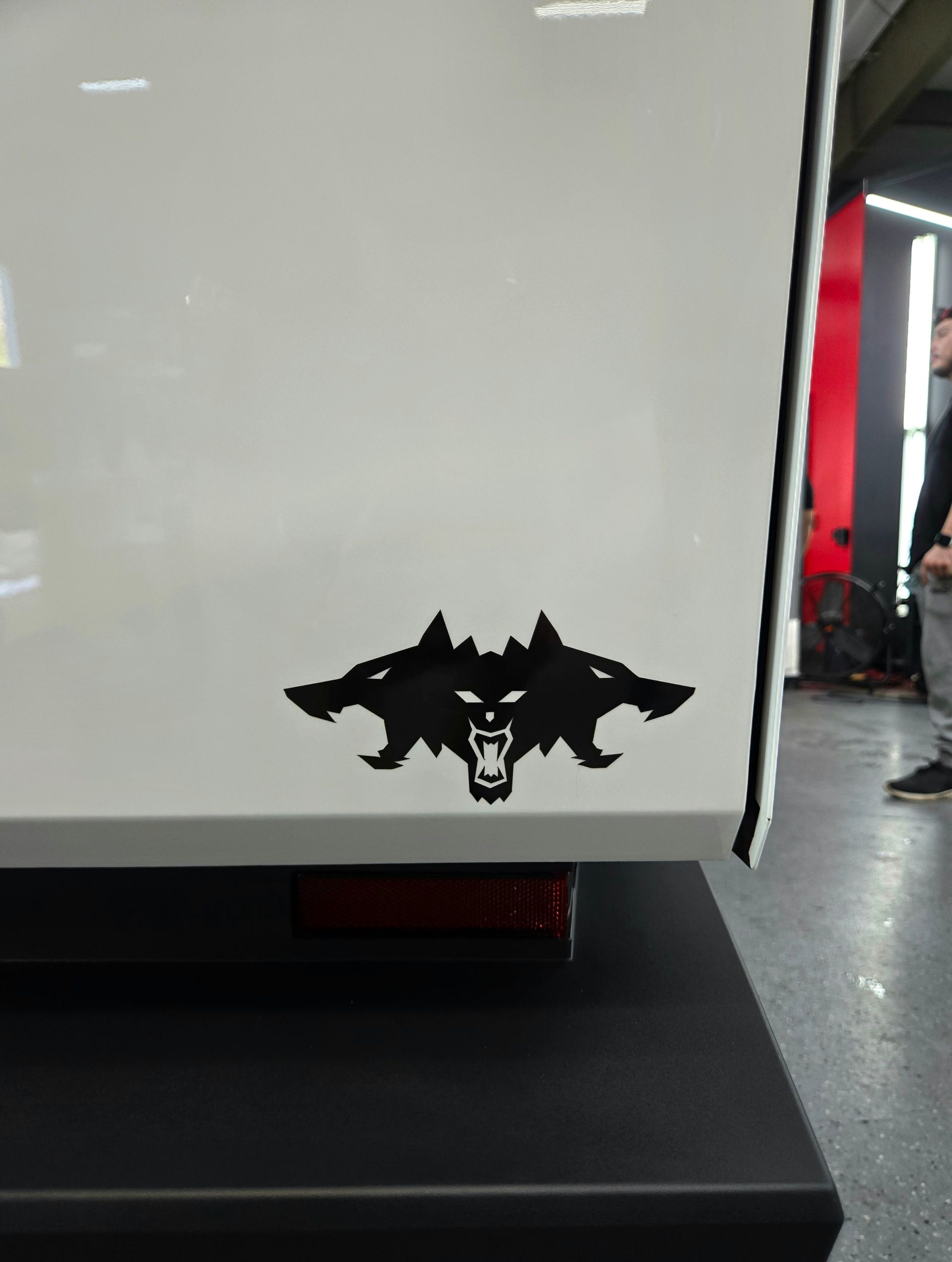 Black wolf decal on a white vehicle, showcasing three snarling wolf heads.