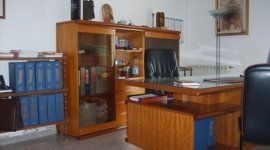 un ufficio con una scrivania in legno e due sedie