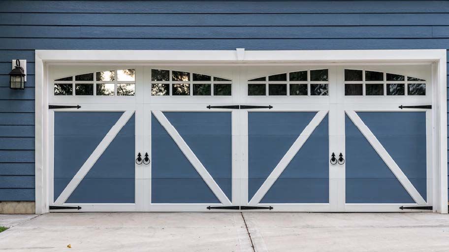A blue and white garage door on a blue house