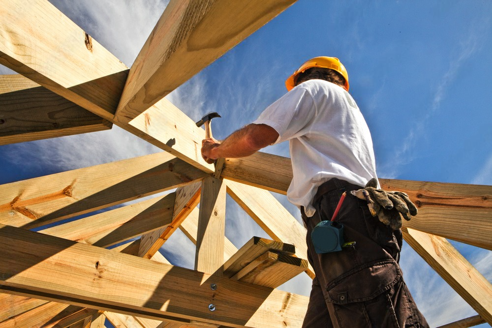 a man is working on a wooden structure with a hammer