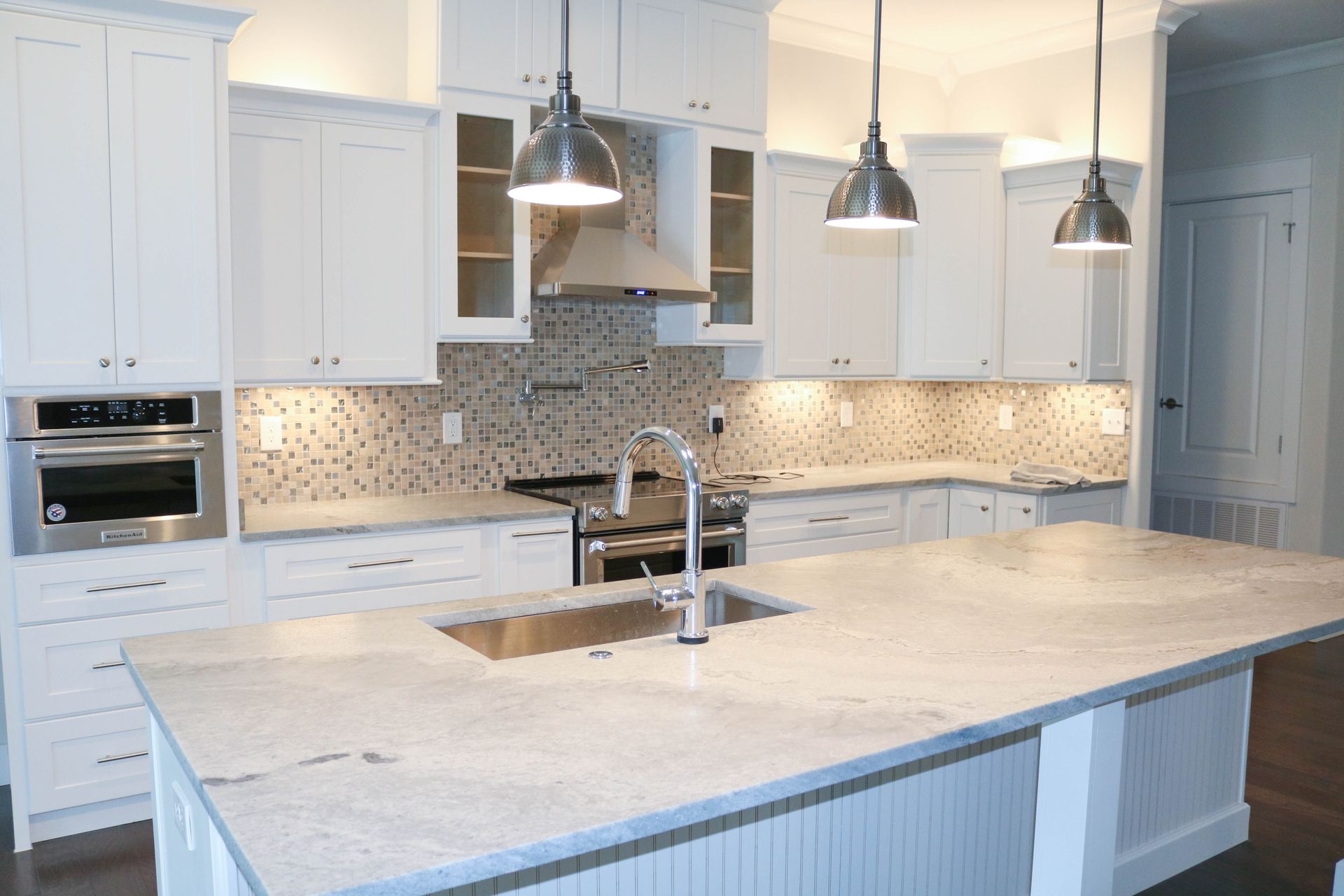 Matte granite kitchen countertops in elegant white and gray color palette.