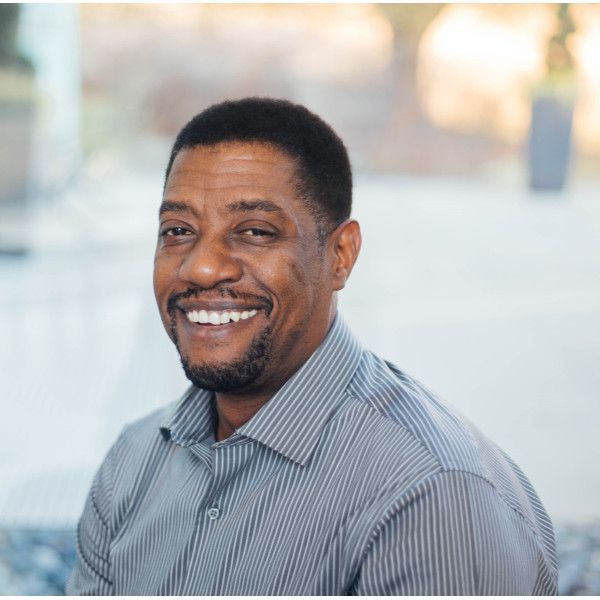 A man in a striped shirt is smiling for the camera