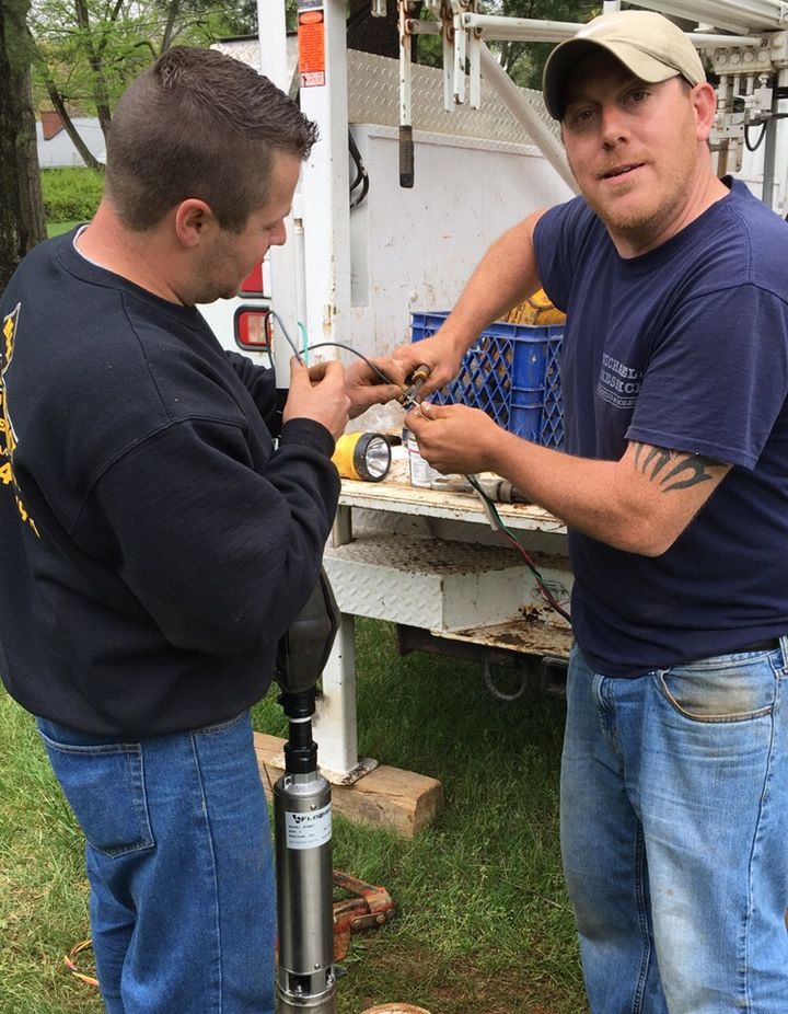 Two Men Are Working On A Electric Wire In Front Of A White Truck - Lambertville, NJ - Mr. Well Pump