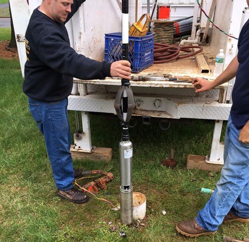 Two Men Are Working On A Machine In Front Of A Truck - Lambertville, NJ - Mr. Well Pump