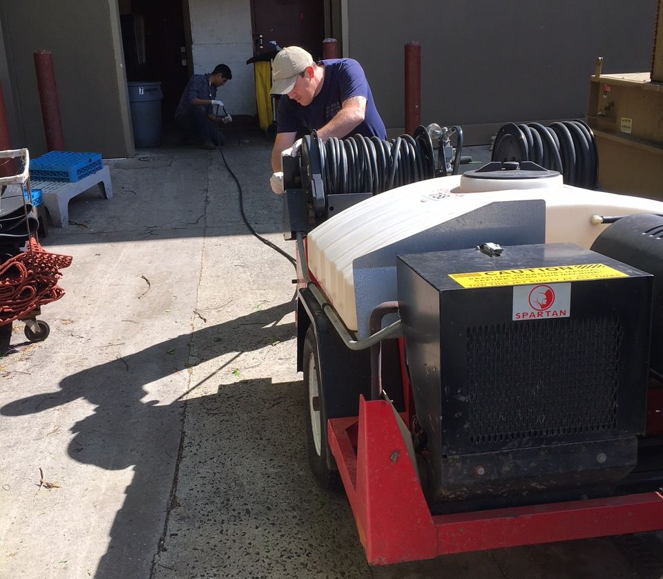 A Man Is Working On A Machine In A Parking Lot - Lambertville, NJ - Mr. Well Pump