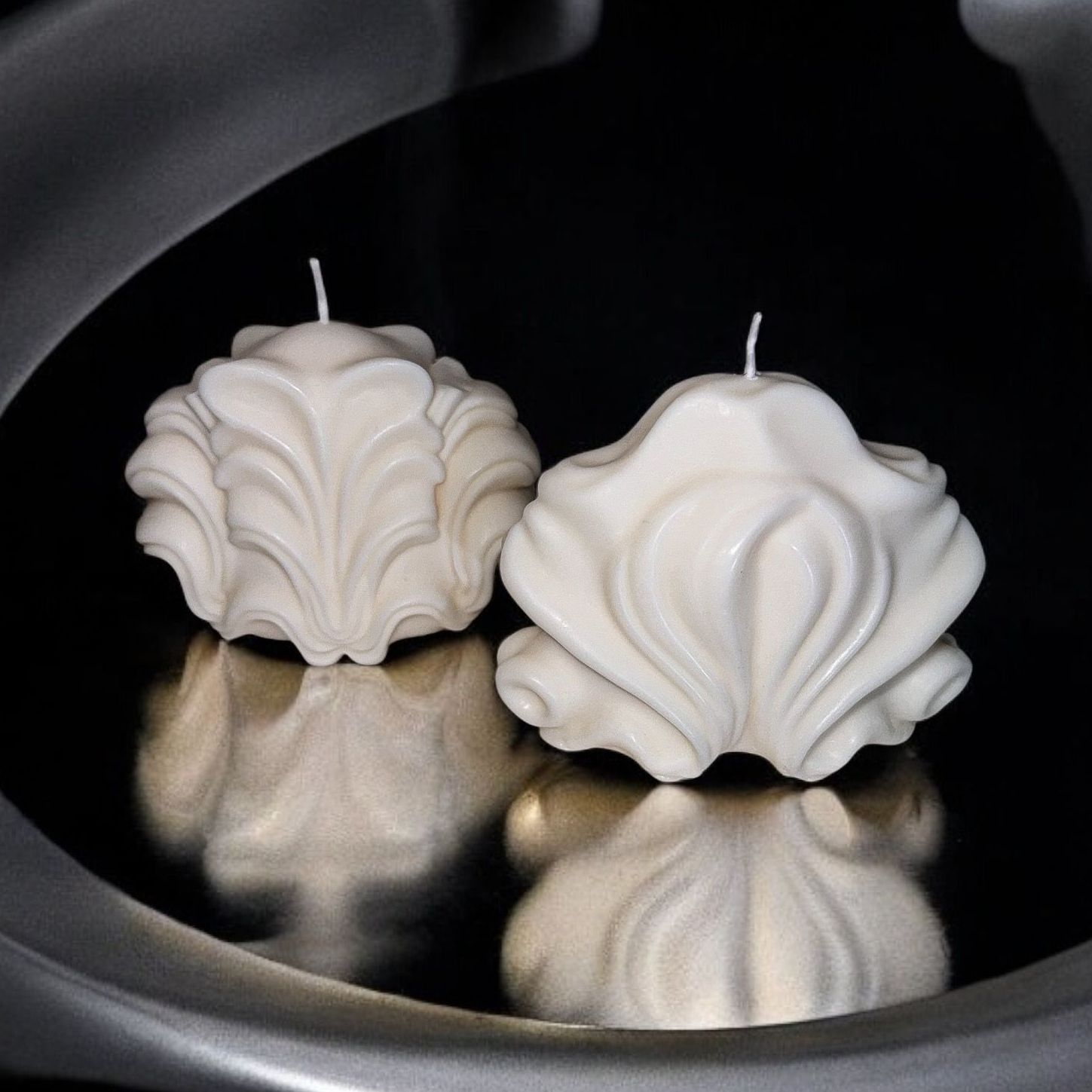 Twee witte kaarsen in de vorm van schelpen