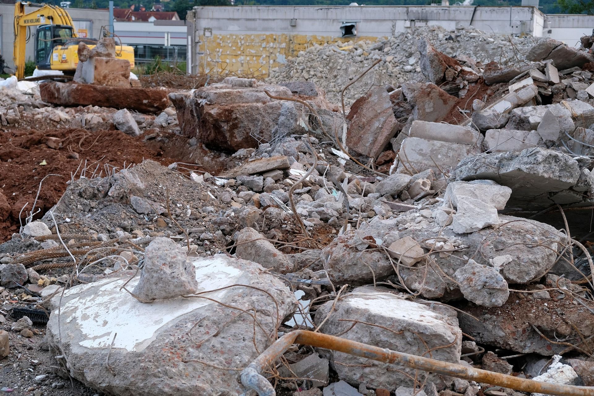 Pile of broken bricks in various colors against a blue sky with white clouds.