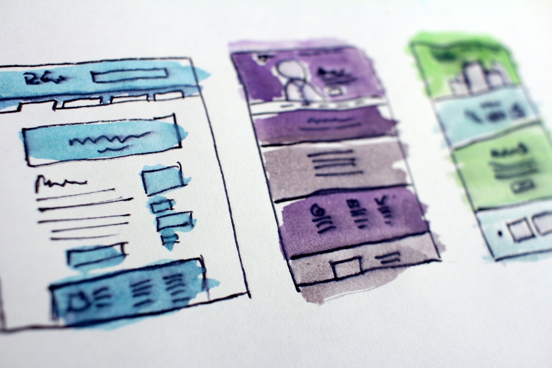 Watercolor sketches of three website layouts: blue, purple, and green, showing different content sections.