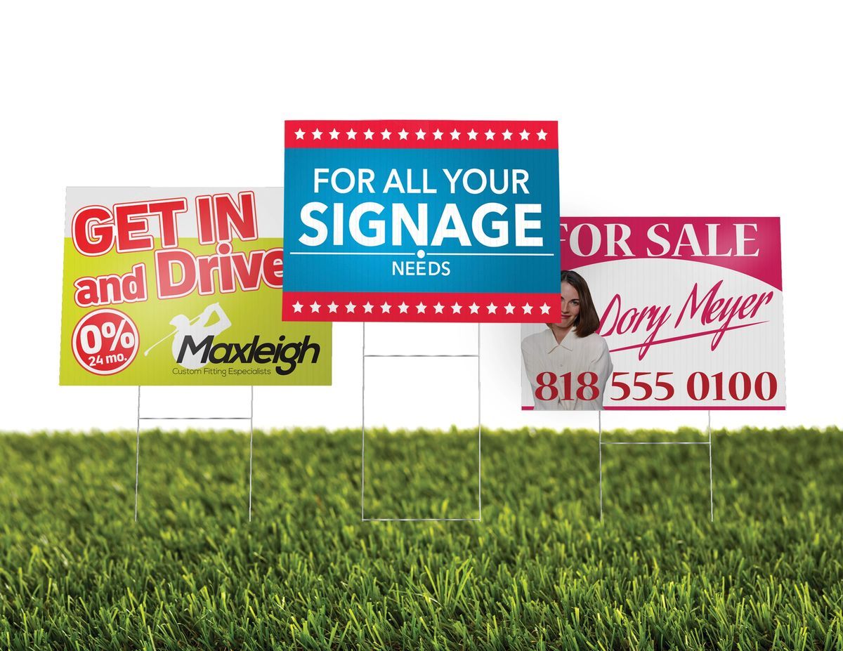 Yard signs on grass, advertising: 