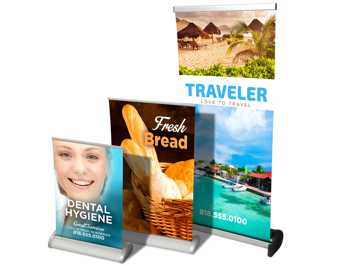 Various roll-up banner stands with different designs: dental hygiene, fresh bread, tropical scene.