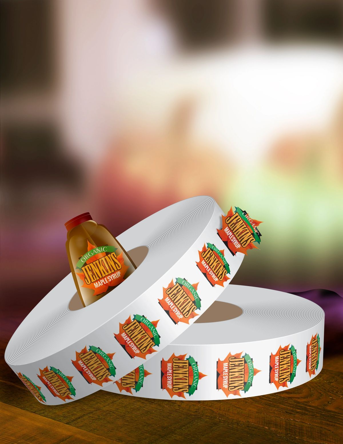 Rolls of white sticker labels with orange and green apple cider bottle graphics, featuring an actual bottle of apple cider.