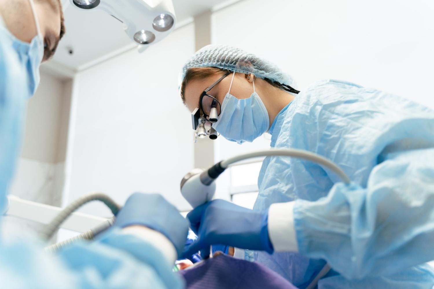 A dentist is working on a patient 's teeth in a dental office.