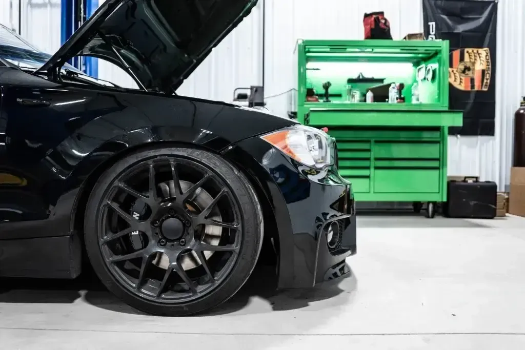 Side view of black car with hood up in garage | Eurocharged