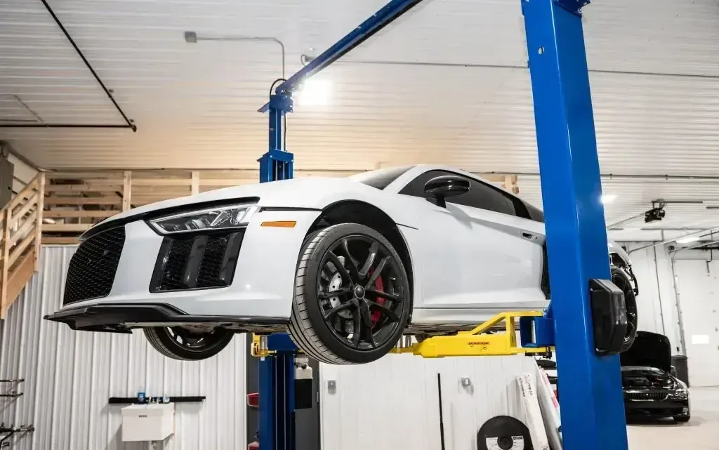 White car raised up in garage on lifts | Eurocharged
