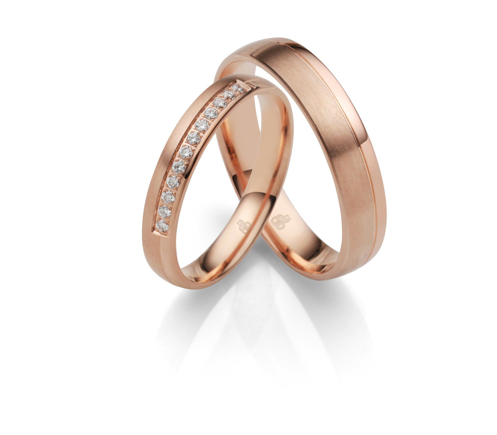 Ein Paar Eheringe aus Roségold mit Diamanten darauf