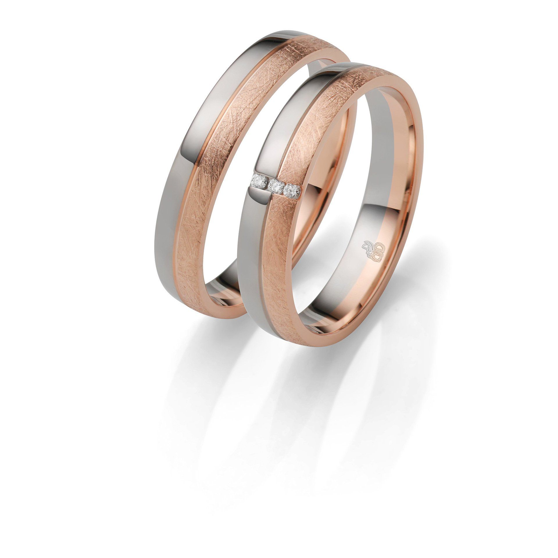 Ein Paar Eheringe mit Diamanten auf weißem Hintergrund