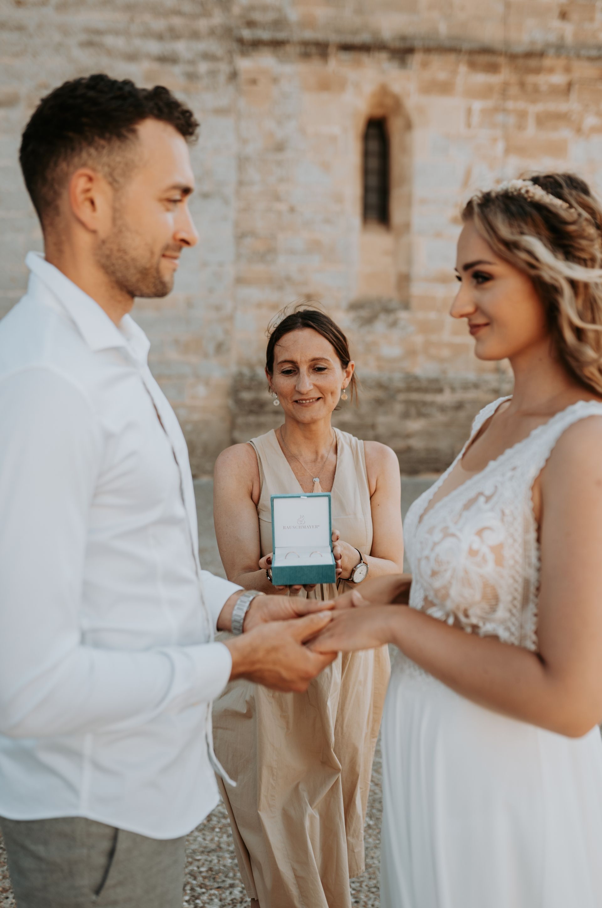 Eine Braut und ein Bräutigam halten während ihrer Hochzeitszeremonie Händchen.