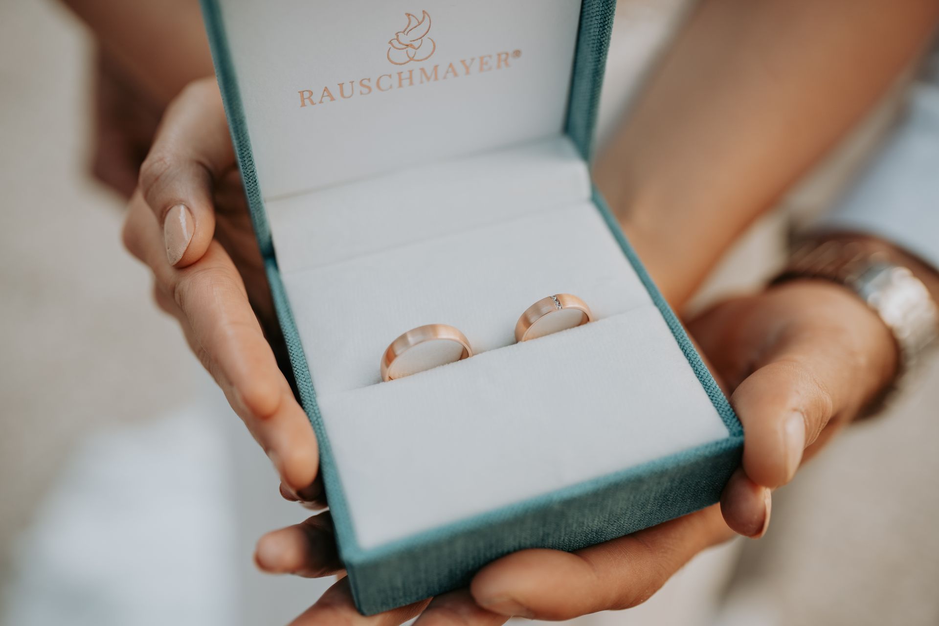 Eine Frau hält eine Schachtel mit zwei Eheringen darin.