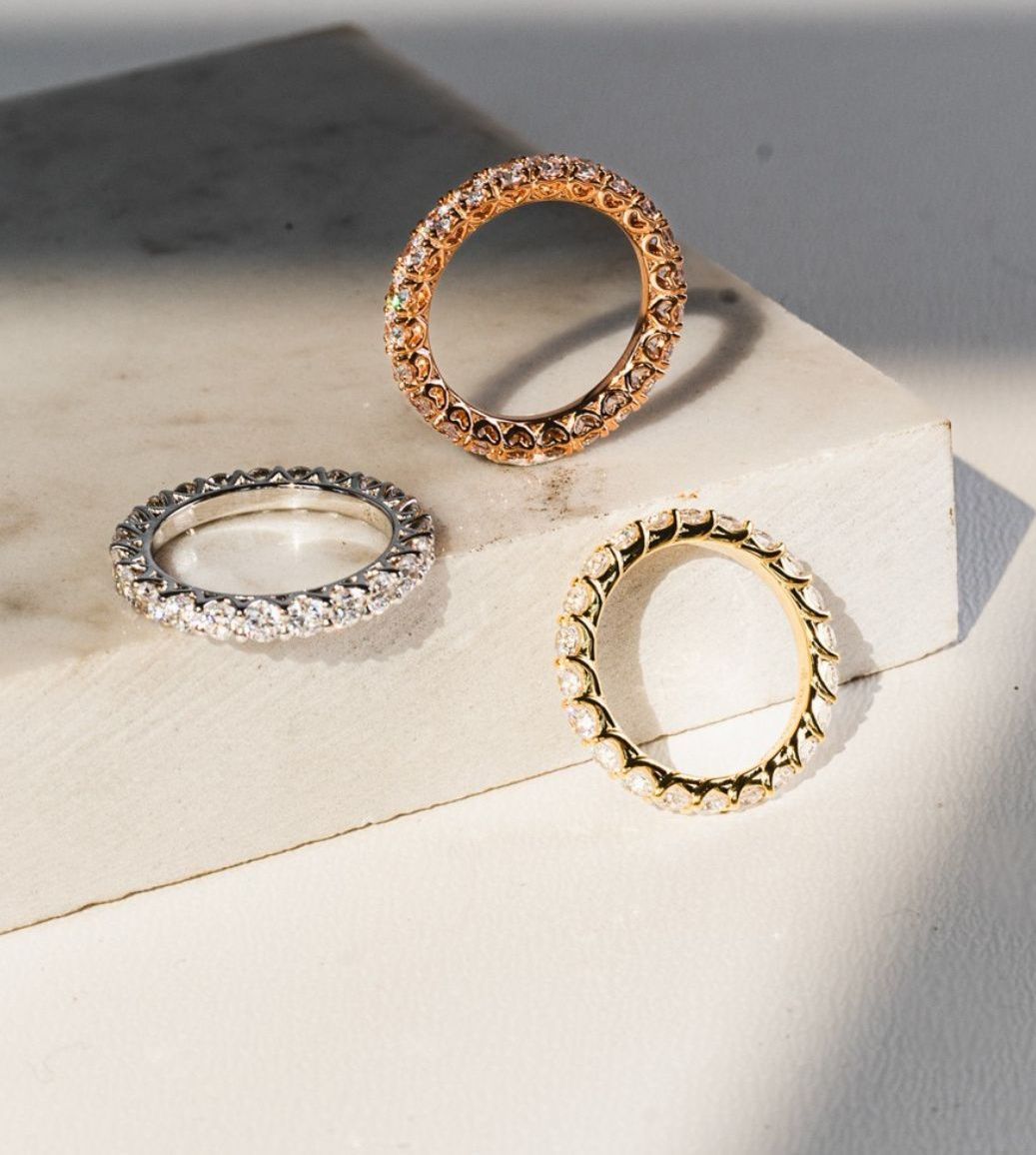 Drei Ringe liegen auf einer weißen Schachtel.