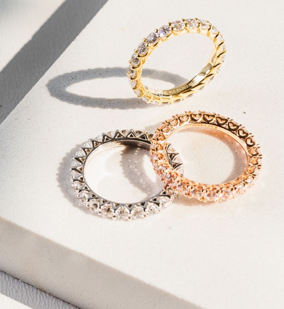 Zwei Ringe liegen übereinander auf einer weißen Fläche.