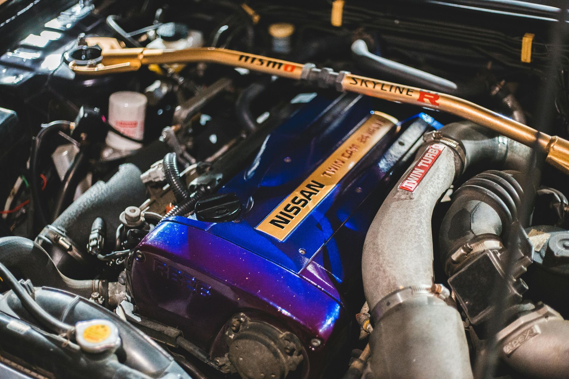 A close up of a nissan engine with a blue cover.