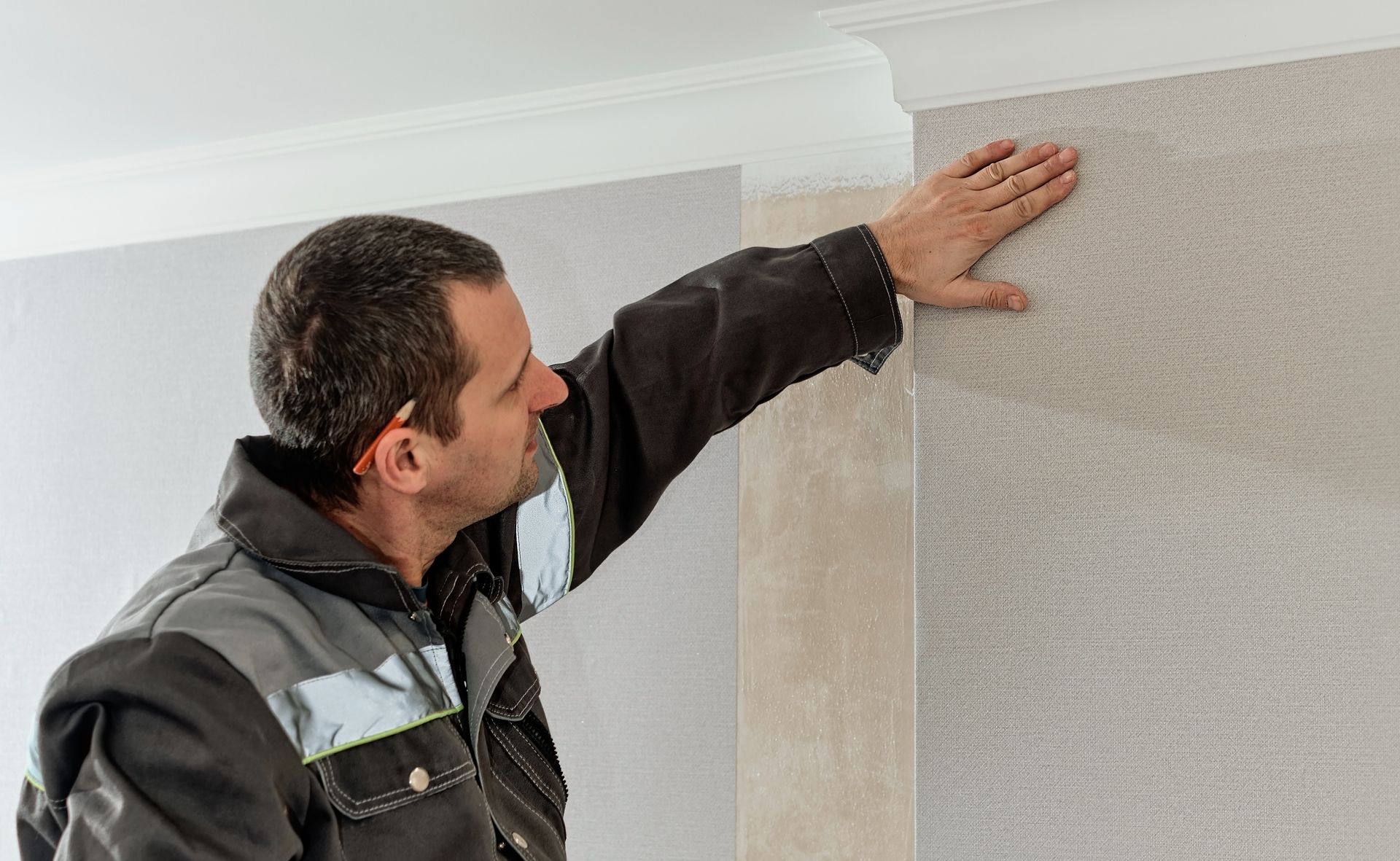 A man is touching a wall with his hand.