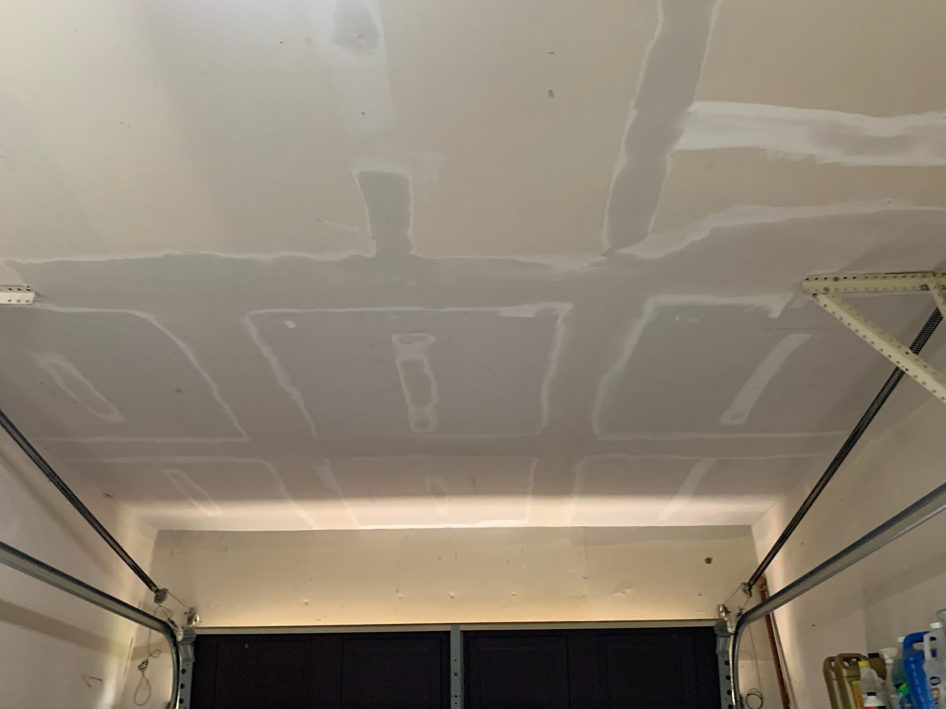 The ceiling of a garage is being painted white.