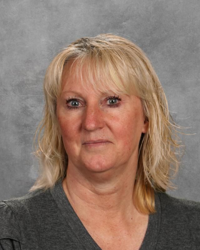 A woman with blonde hair and blue eyes is posing for a picture.