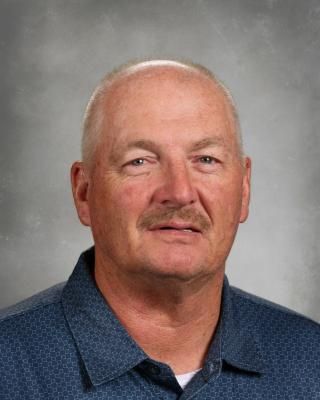 A man with a mustache is wearing a red and black striped shirt.